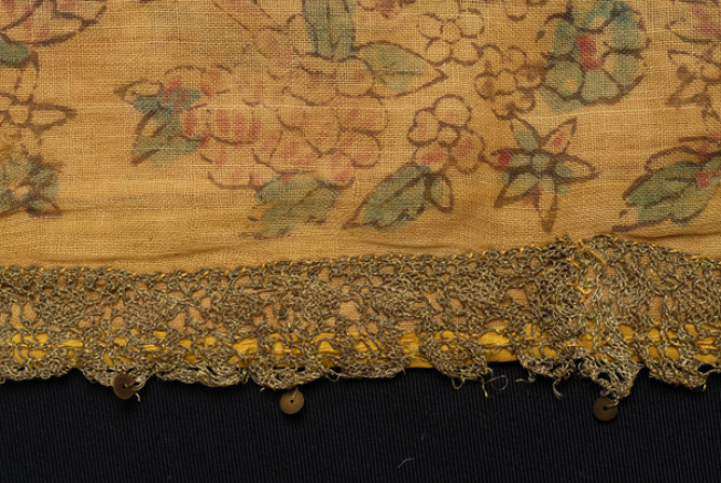 Detail of the applique decoration with gold machine lace