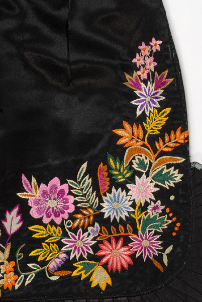 Bottom of the apron, detail of the decoration with multicoloured vegetal motifs, crafted with various stitches (riza (stem stitch), light stitch, rococo)