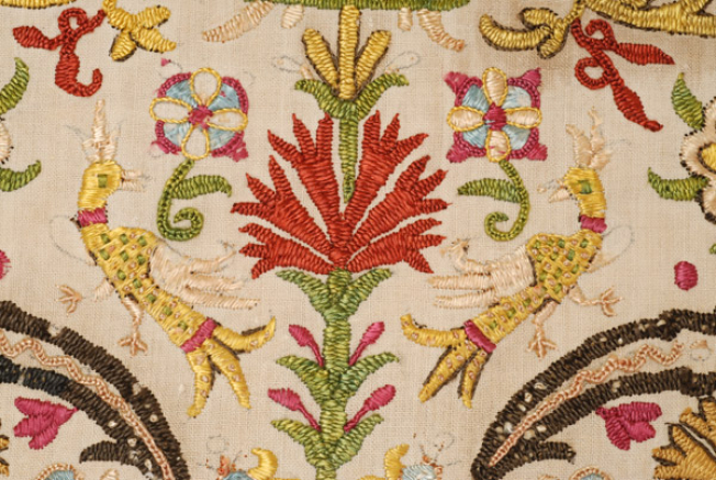 Detail of the embroidery, stylized flower pot with facing and converse birds.
