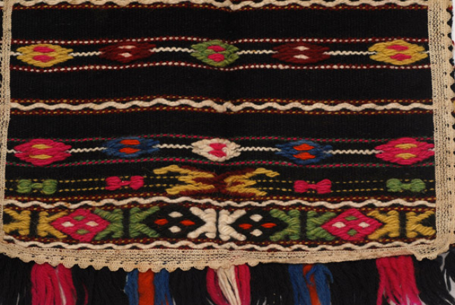 Detail of the decoration, band with stefanoudi and band with skroupto chali. Applique lace and small fringes at the edge.
