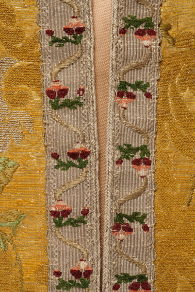 Detail of the applique decoration with gold chevron decorated with gold thread and cotton thread with hair