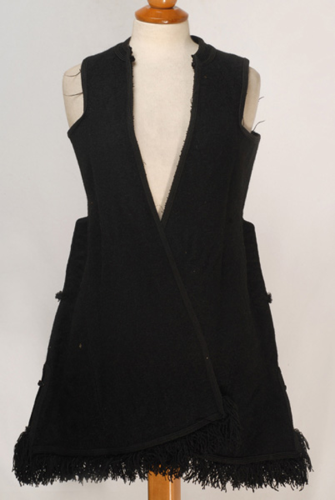 Sleeveless exterior overcoat made of black horse cloth, ornamented with plain coloroured cordons and with woollen fringes