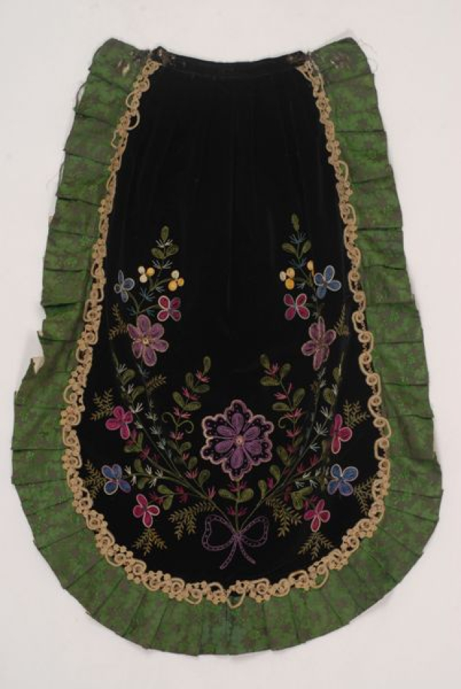Black velvet apron embroidered with multicoloured silk threads. Trimmed around with flounce made of green satin