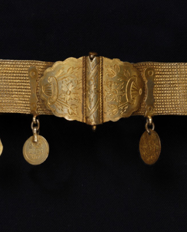 Gilt choker with two curved cast plates bearing engraved floral decoration