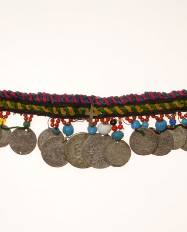 Sia, pectoral ornament of older type from Oreini, Serres made of multicoloured woollen cordons, from where sixteen coins are hanging. Decoration with coloured beads in different sizes.