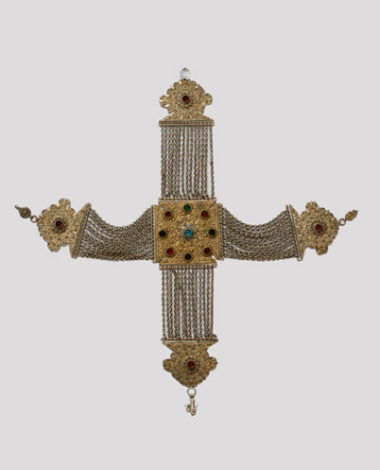 Golded crossed kioustekichest ornament, with wiry decoration and multicoloured stones