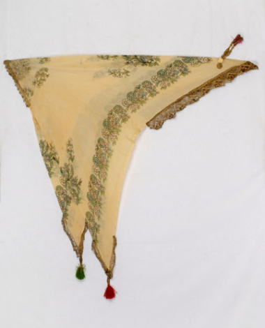 Yellow printed kerchief with leafy scrolls and flowers. Applique decoration with gold lace, guilded coins and tassels