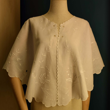 Fichu from the early 20th century. It served as a protective shawl that a woman would arrange around her shoulders while caring for her hair, to stop loose hairs from falling on her clothes. (It’s missing the ribbons that were used to arrange and tighten the shawl on the shoulders and around the neck.) It belonged to Frosso Karydi (Smyrna, 1916–Athens, 1999). CMLE, Accession No. 16626. Donated by Penny Saccopoulou-Valtazanou. Photo: Hara Dendia.