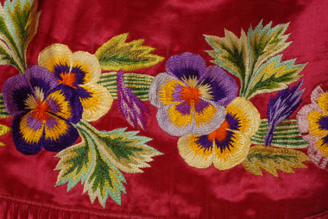 Satin apron in a warm shade of cherry embroidered with multicoloured silk threads