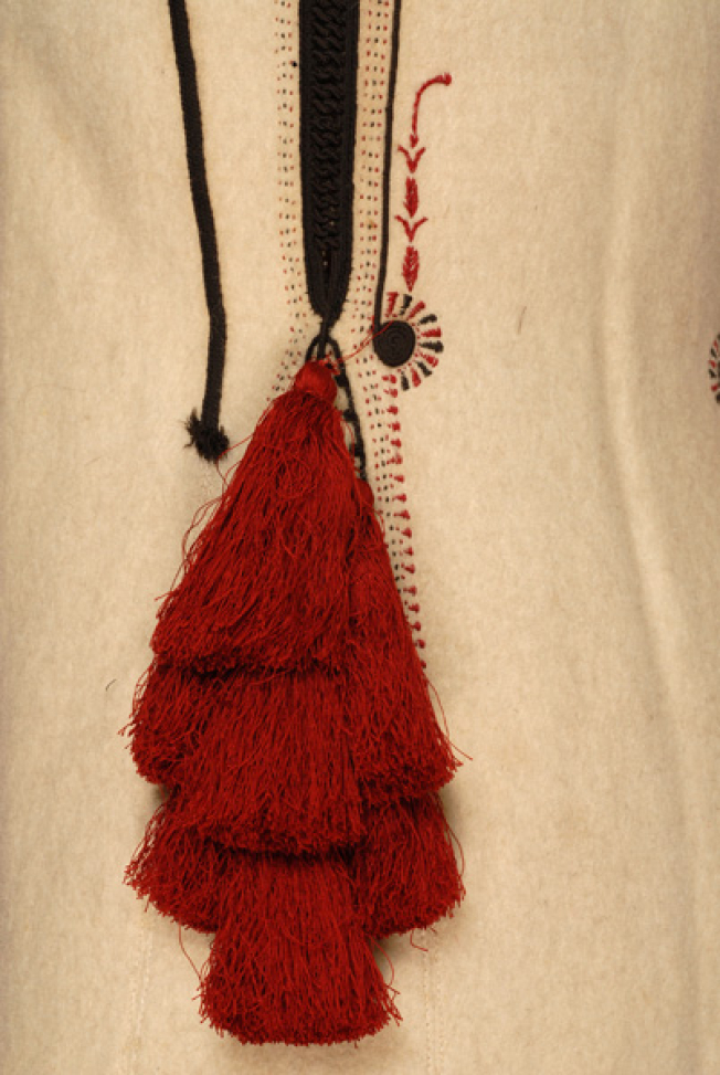 Embroidery at the back: radial coil, red stitches, tassels