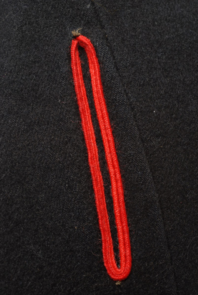 Right front panel, vertical opening (pocket) framed by cordons