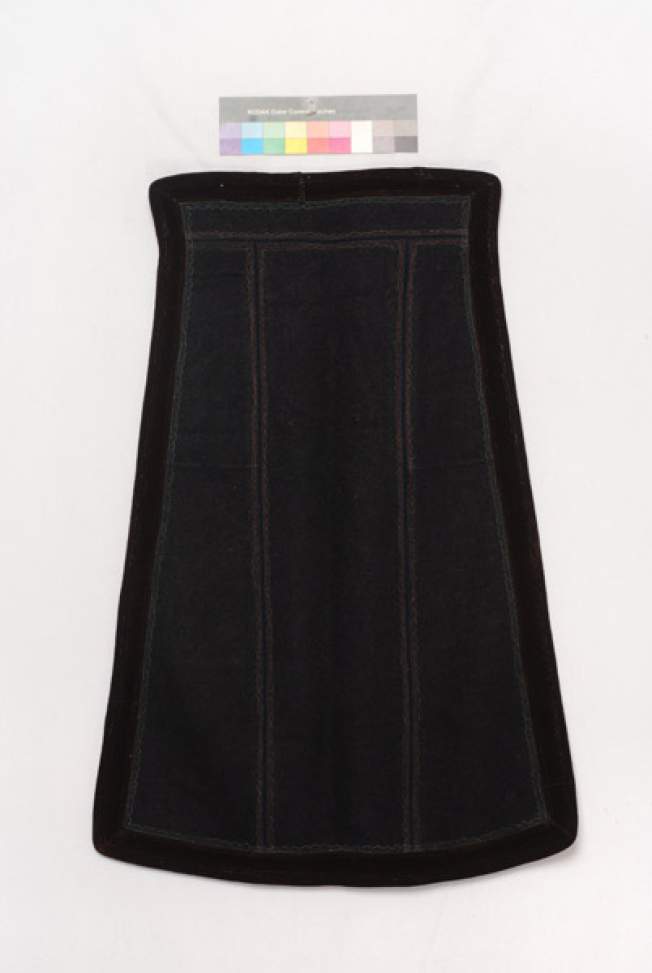 Black skoutisia apron, ornamented with plain multicoloured stitches around, trimmed with brown velvet band