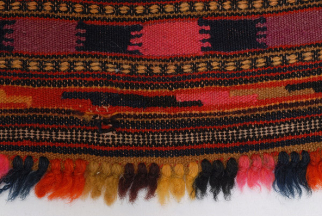 Detail of the embellished decoration at the lower end of the apron and its fringed end