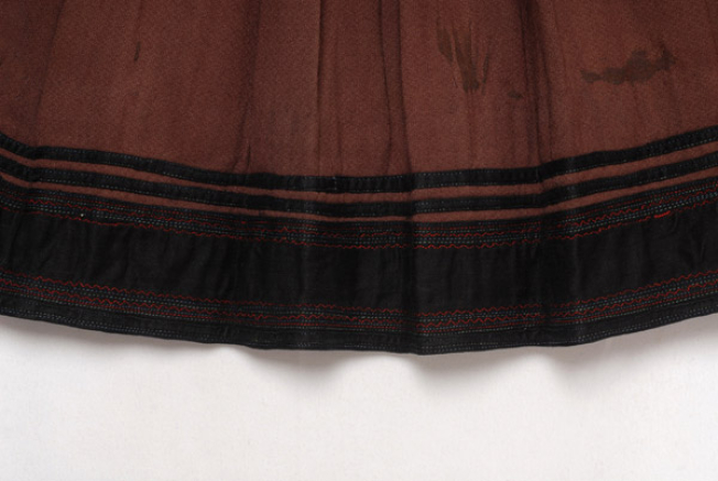 Ποδόγυρος, λεπτομέρεια διακόσμησης με επίρραπτες σατέν κορδέλες και κομμάτι από μαύρο βαμβακερό ύφασμα με χρωματιστά γαζιά