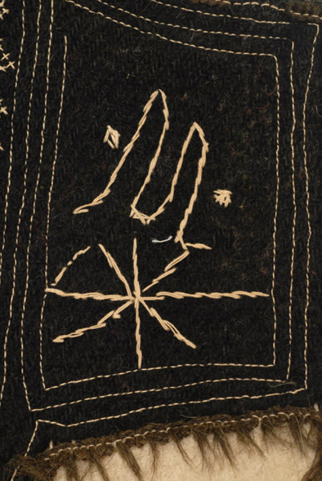 Μπροστινό φύλλο στο ύψος της μασχάλης, μαύρο σαγιακένιο κομμάτι με το μονόγραμμα "Μ"
