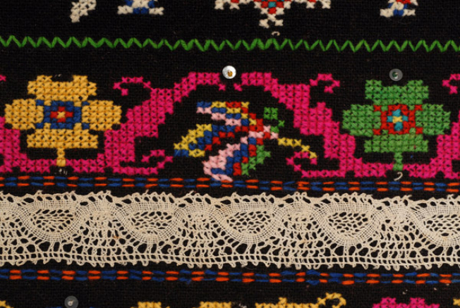 Detail of the decoration, band with embroidered floral motifs and applique lace 