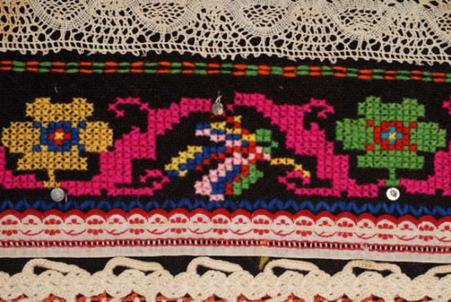 Detail of the decoration, band with embroidered floral motifs and applique fillet sold by the metre