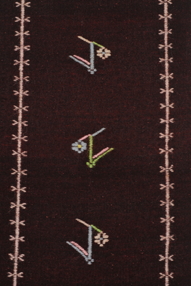 Detail of the decoration, embroidered vertical stripes with stylized vegetal motif in between