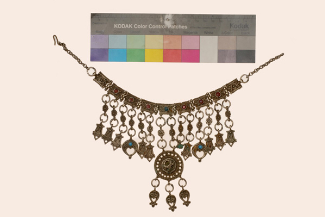 Kremassi, silver ornament (lucky charm) made from oblong cast plates decorated with colourful stones. It has various suspended elements and a central round plate (Northern Sporades?)