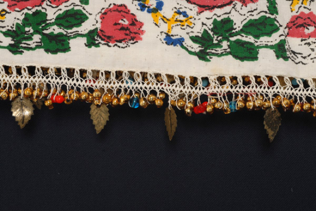 Detail of embroidered decoration, bibila (crocheted lace) with metal foil, little bells and pitsilia (beads)
