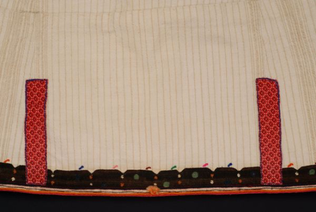 Λεπτομέρεια διακόσμου στην ένωση της μάνας με το λαγκιολούδι με επίρραπτο τσίτι. Δεξιά και αριστερά, κεντητή ταινία γαϊτάνι και σειρήτι στην απόληξη