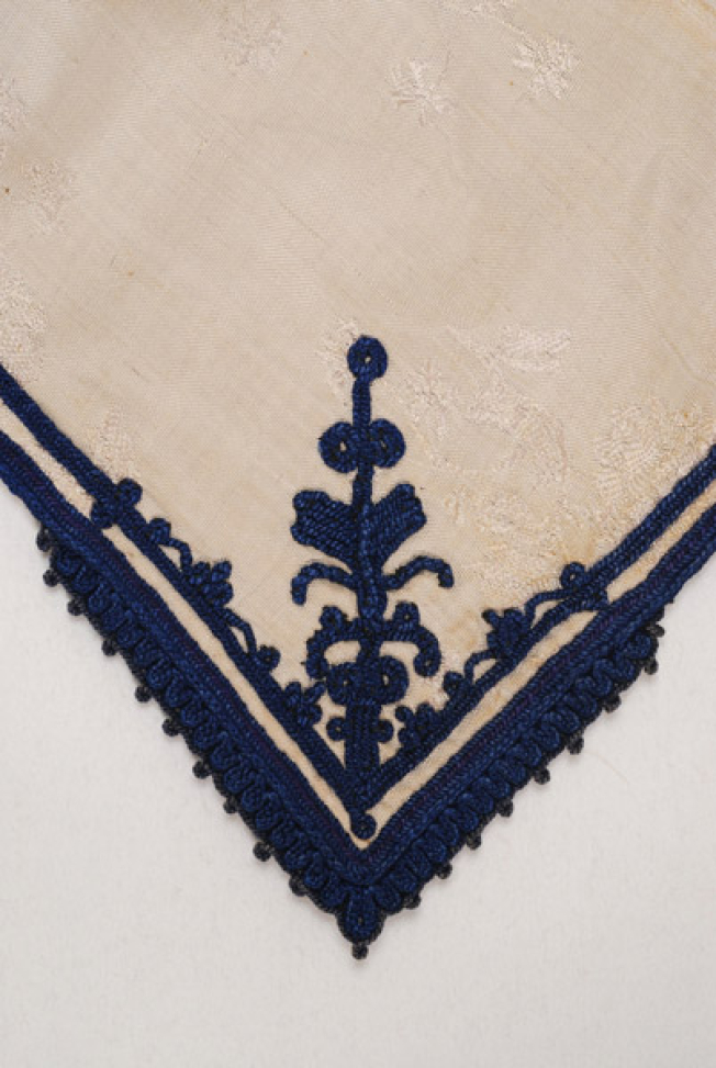 Detail of the decoration at the front corner: flower embroidered on the brocaded fabric
