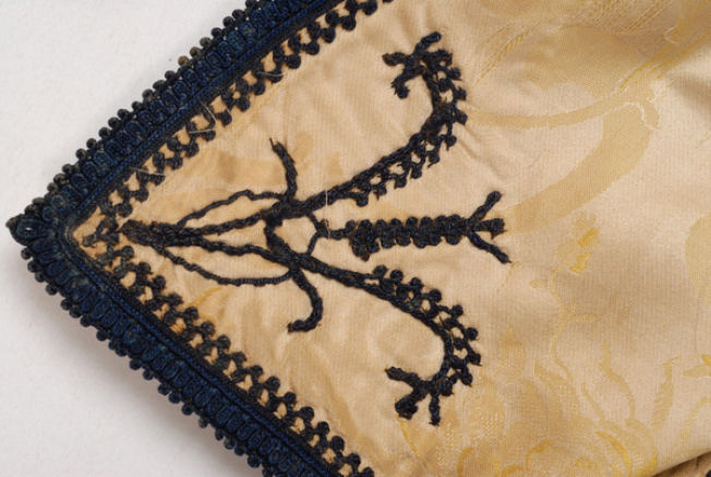Detail of the decoration at the front corner: flower embroidered on the brocaded fabric