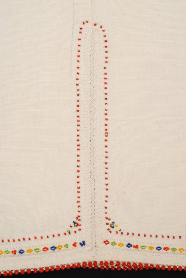 Border, detail of the lacy band of the seam and applique decoration with red beads