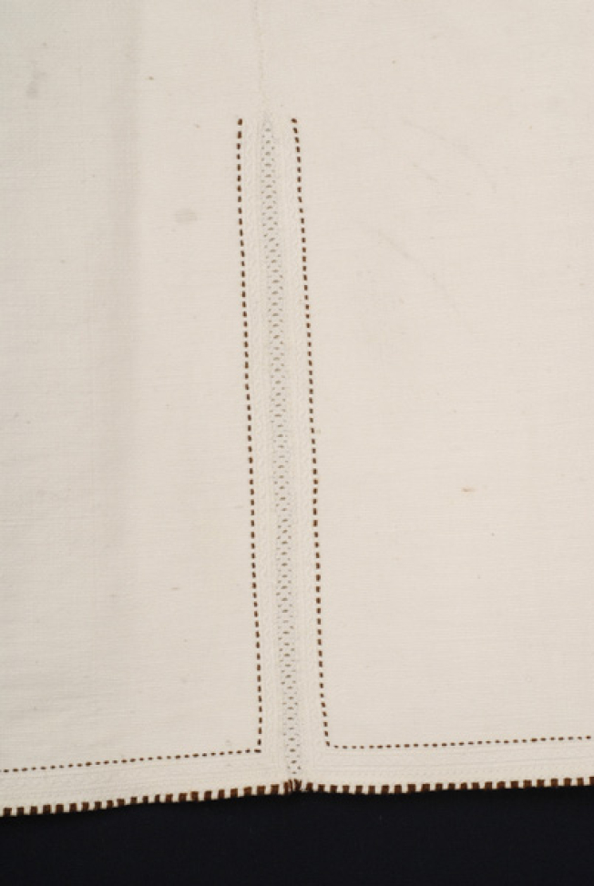 Border, detail of the lacy band and the embroidered decoration