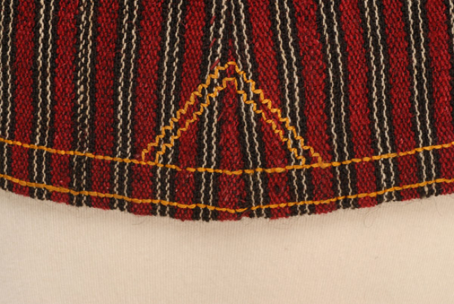 Detail from the hem of the dress at the back, where the fastening stitch ountitsa and the plain embroidery are traced 