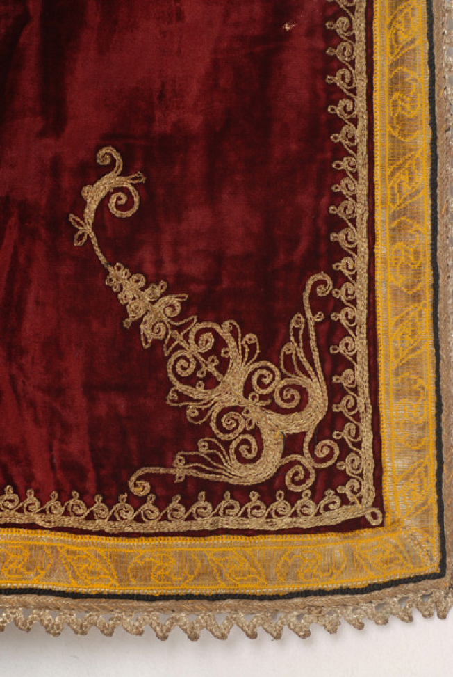 Detail of the decoration of the front corner: embroidered stylized motif and spiral meander, applique gold fillet and lace made of silver thread