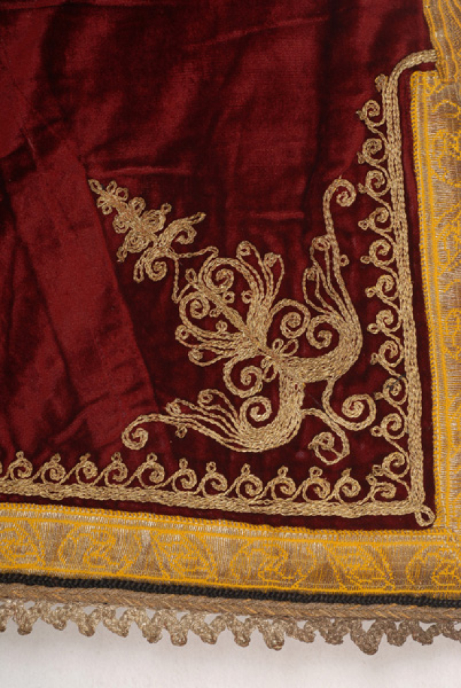 Detail of the decoration of the side panels: embroidered stylized motif and spiral meander, applique gold fillet and lace made of silver thread