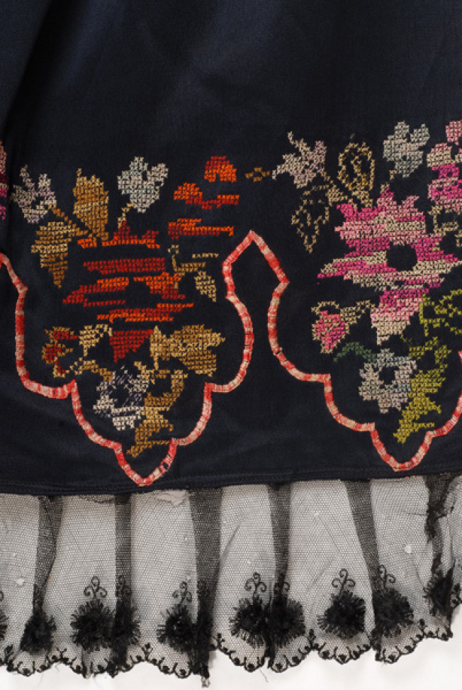 Detail of the embroidered decoration. Edge with black machine lace 