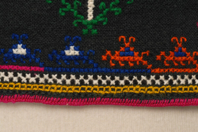 Λεπτομέρεια κεντητού διακόσμου στο γύρο του ποδόγυρου: γκαϊτάνι, τιέλι θρίτουρ, ασπρόμαυρες σειρές και σχηματοποιημένα μοτίβα