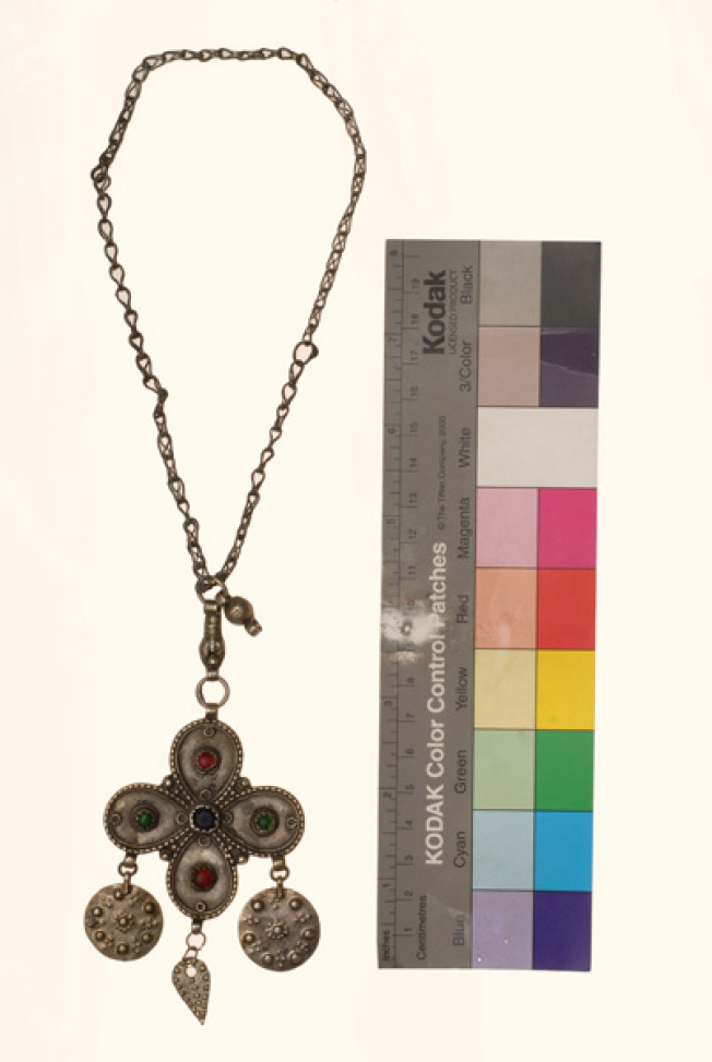Silver cross decorated with variegated glass stones and suspended grainy elements