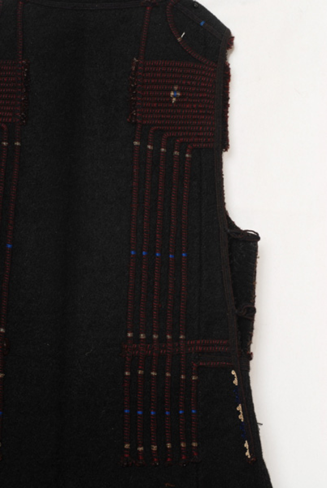 Πίσω φύλλο, επίρραπτη διακόσμηση με μαύρα μάλλινα σεράδια και σχηματοποιημένο διάκοσμο με σταυρόσχημο μοτίβο