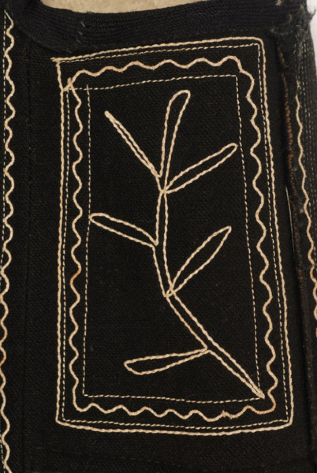 Μπροστινό φύλλο στο ύψος της μασχάλης, επίρραπτο κομμάτι μαύρης τσόχας με σχηματοποιημένο φυτικό διάκοσμο