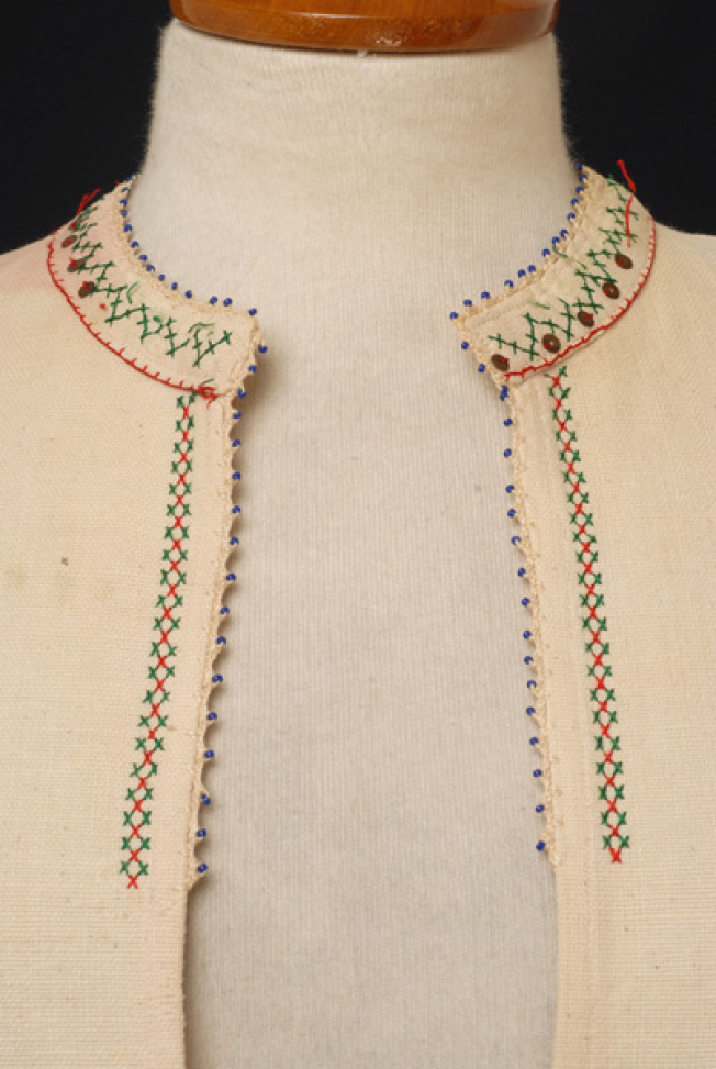 Detail of the decoration with fine lace and beads, embroidery and spangles at the neck border and the front opening