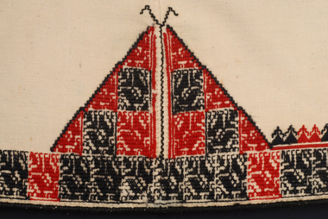 Detail of the embroidered decoration at the joint of the oblique panels: embroidered joint framed by triangles.
