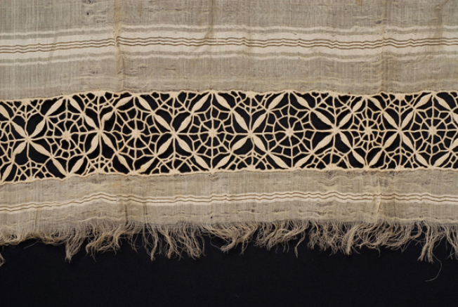 End of bolias, detail of the decoration with cast, white, open-work embroidery