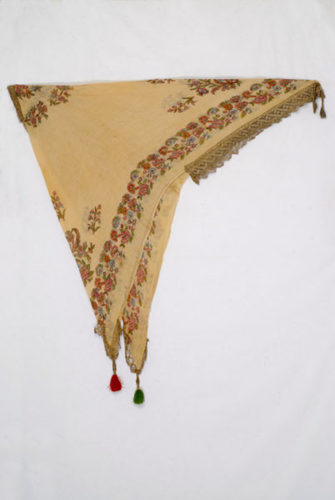 Printed yellow cotton head kerchief with leafy scrolls and flowers. Applique decoration with gold lace and colourful silk tassels