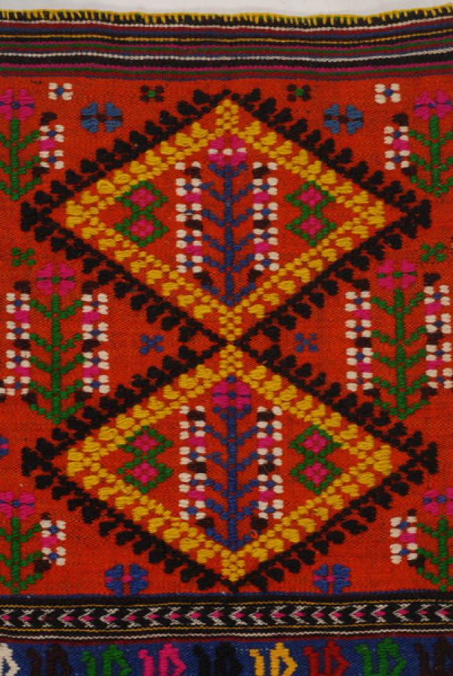 Detail of the embellished decoration, two equitant lozenges at the centre of the apron