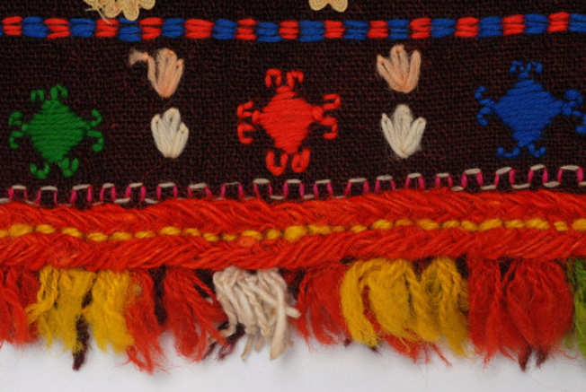 Detail of the decoration, wool gaitani and fringed ends from fullen wool fabric