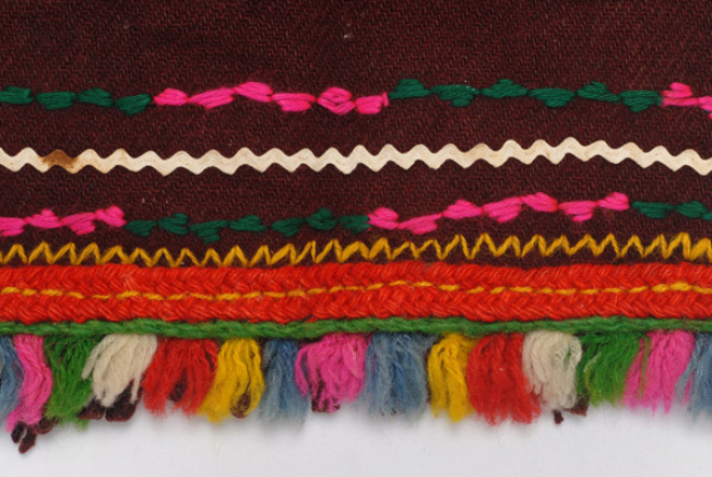 Detail of the decoration, embroidered lines, applique braid, woollen gaitani, small fringes and multicoloured small tassels made of sayiaki (fullen wool fabric) at the edge