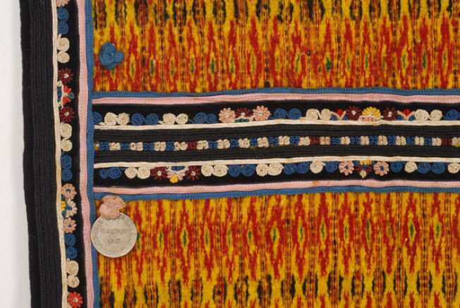 Οριζόντια ραφή, επίρραπτη διακόσμηση με χρωματιστές κορδέλες, βελούδινα κομμάτια κεντημένα με ανθικά και γεωμετρικά μοτίβα και ροζέτες με νομίσματα 