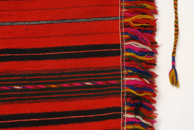 Embellished decoration, woollen fringes and a tassel at the cord