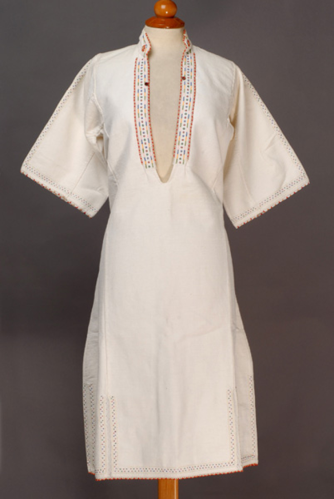 White cotton woven chemise, ornamented with mat and glistening beads, buttons and embroideries with coloured cotton threads 