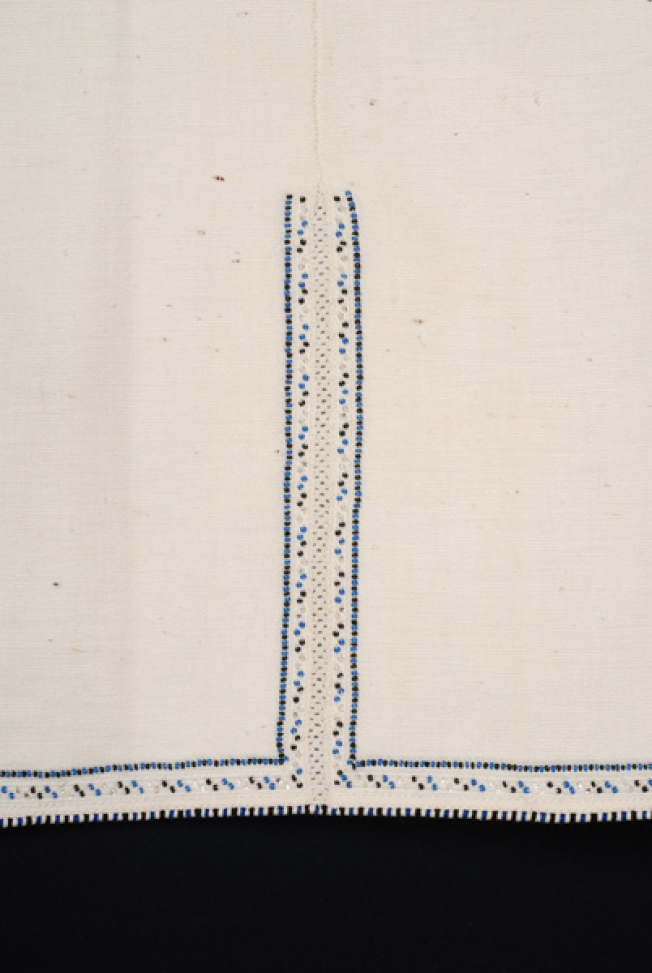 Border, detail of the lacy band of the seam and applique decoration with coloured beads