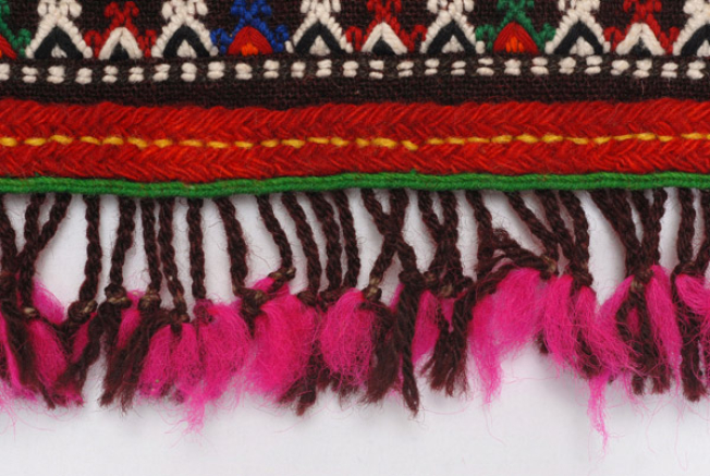 Detail of the decoration, applique wool gaitani, wool cord and fringed ends made of fullen wool fabric