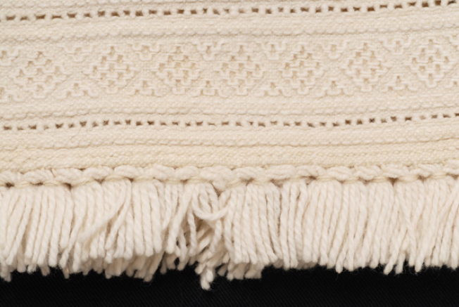 Edge of the border, with short white woollen fringes, the podres